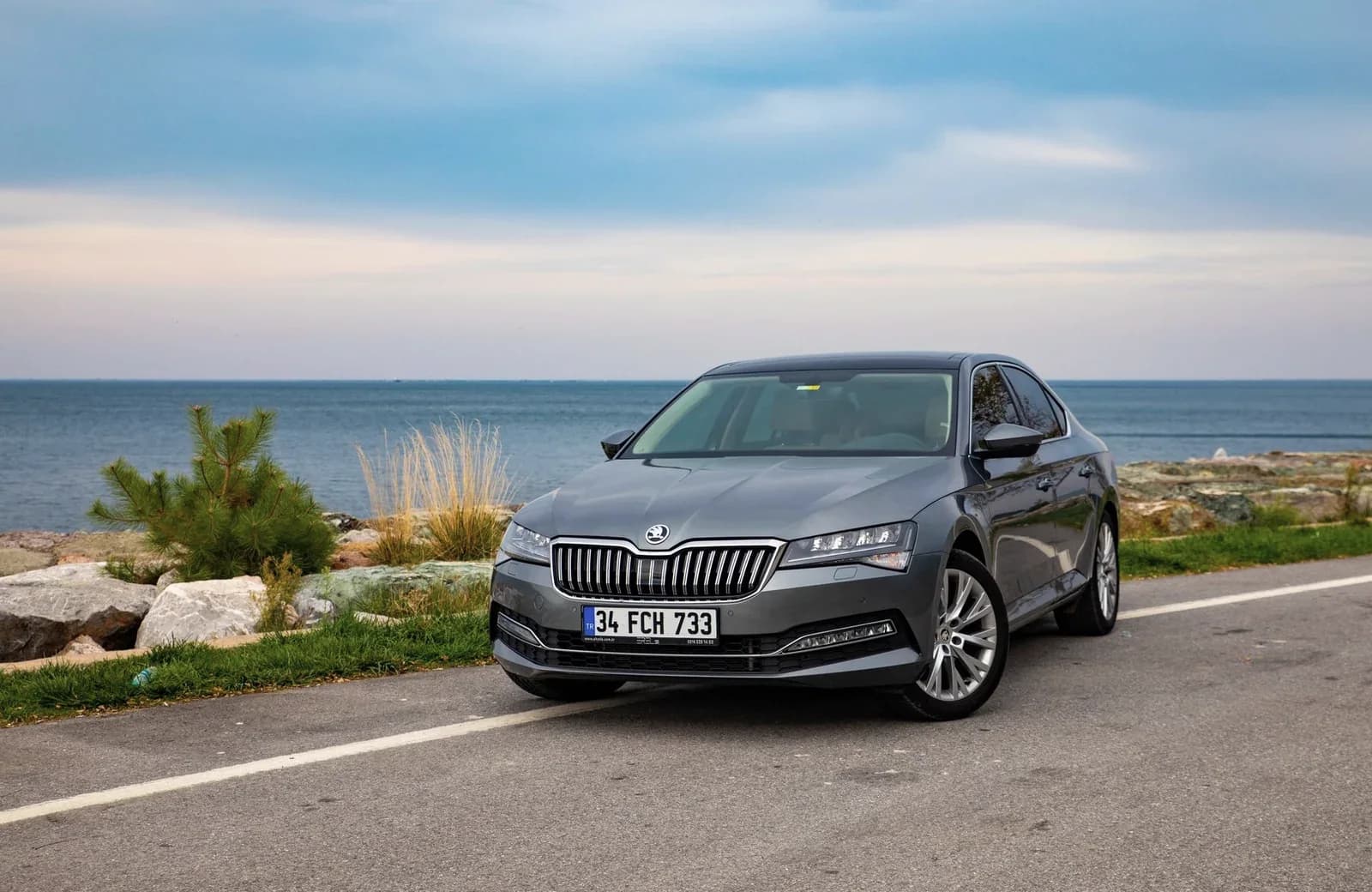 En grå Skoda holder parkeret ved kysten
